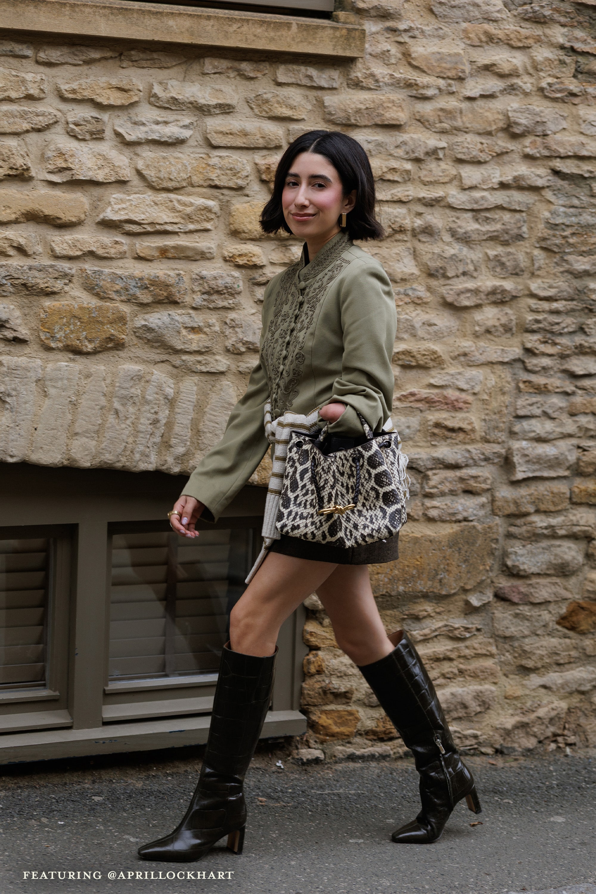 woman walking while wearing the sylvia knee high boot in croco leather