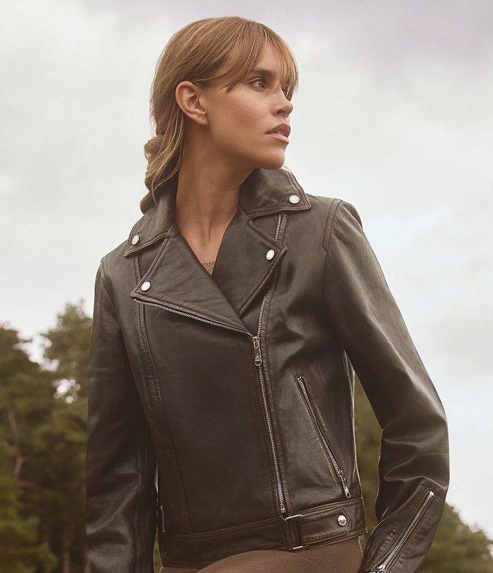 woman wearing a sam edelman asymmetrical leather jacket in dark brown