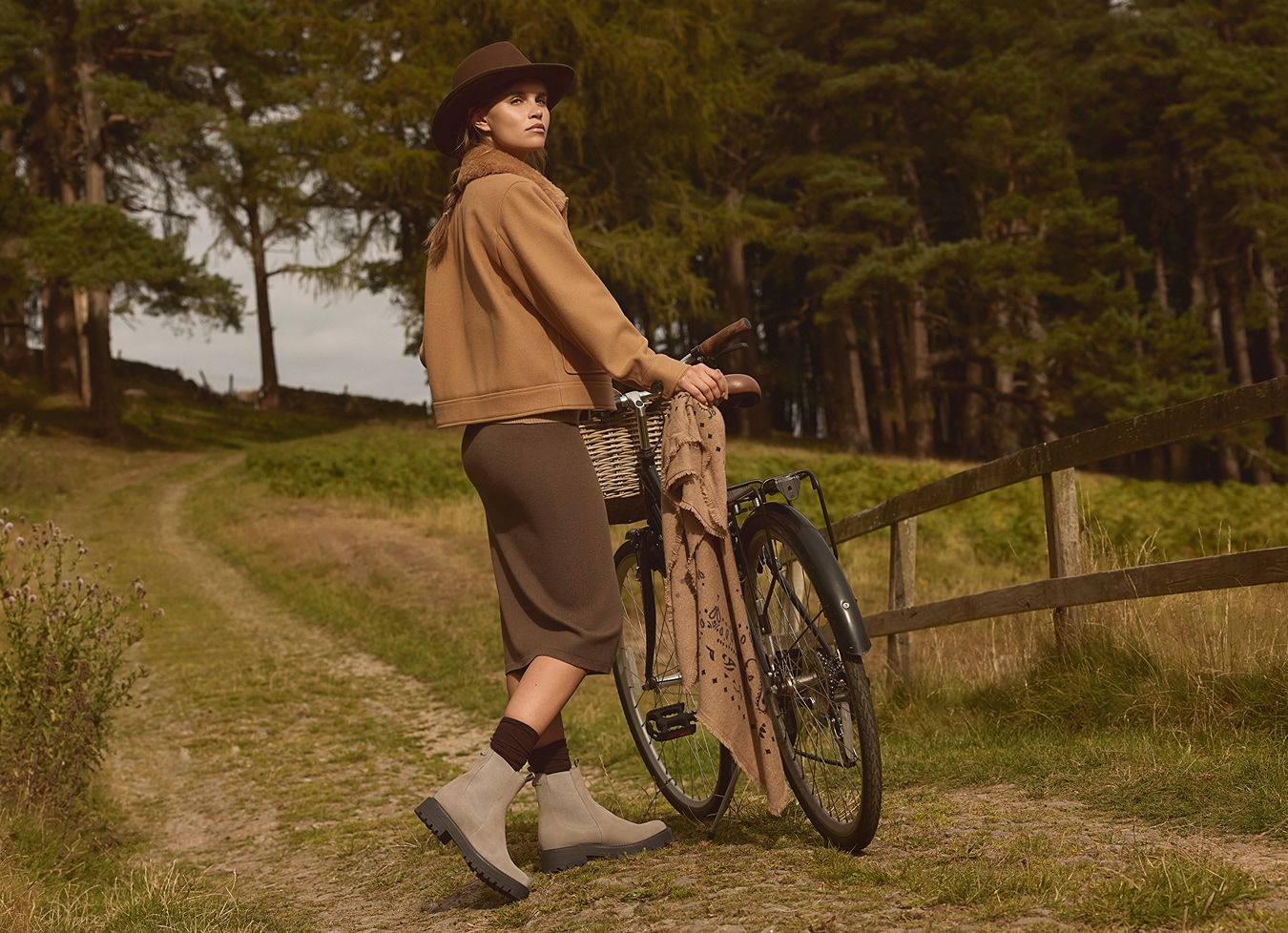 chic woman on a farm standing alongside her bike while wearing the laguna lug sole boot