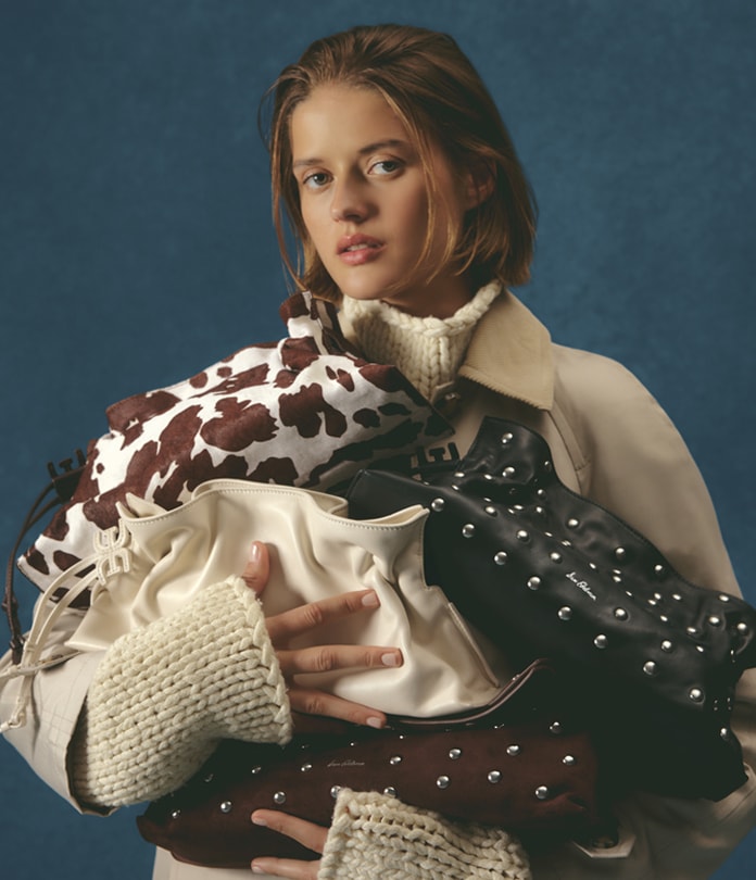 woman holding many handbags by sam edelman