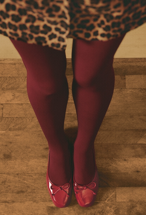 woman wearing a leopard dress with red tights and shoes