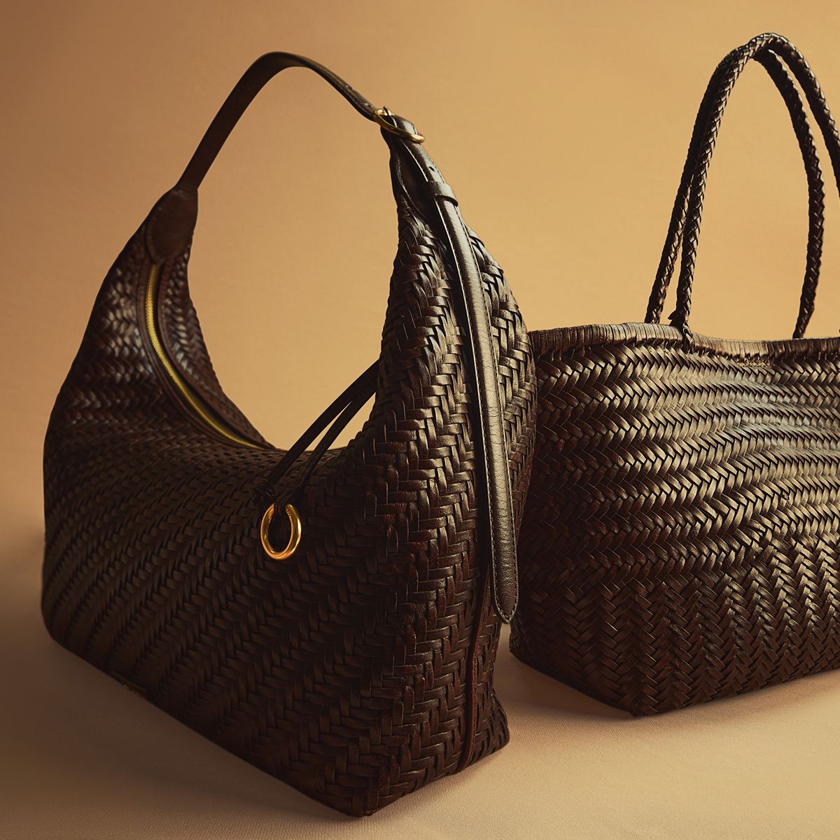 Sam Edelman Kasey hobo bag in spiced pecan woven leather, sitting next to a matching woven tote